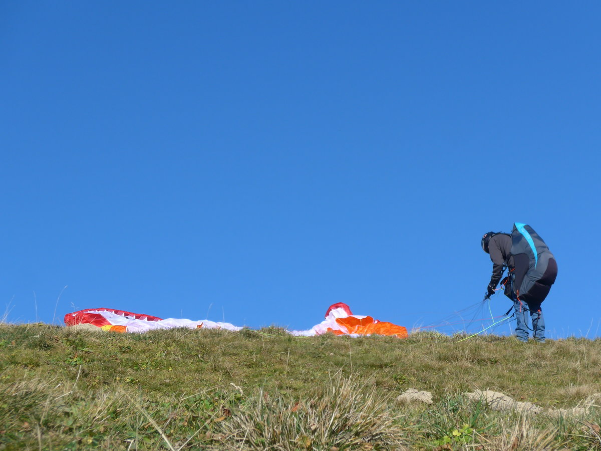 (185'853) - Gleitschirmpilot bei den Vorbereitungen zum Start am 15. Oktober 2017 am Tschenten ob Adelboden