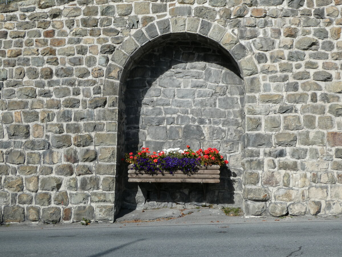 (241'097) - Blumenschmuck in der Mauer am 12. Oktober 2022 beim Bahnhof St. Moritz
