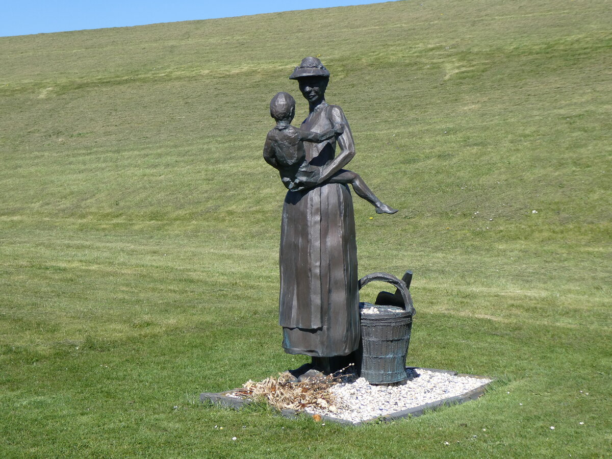 (274'681) - Fischersfrau mit Kind wartet auf ihre Familienmitglieder am 5. April 2025 in Moddergat